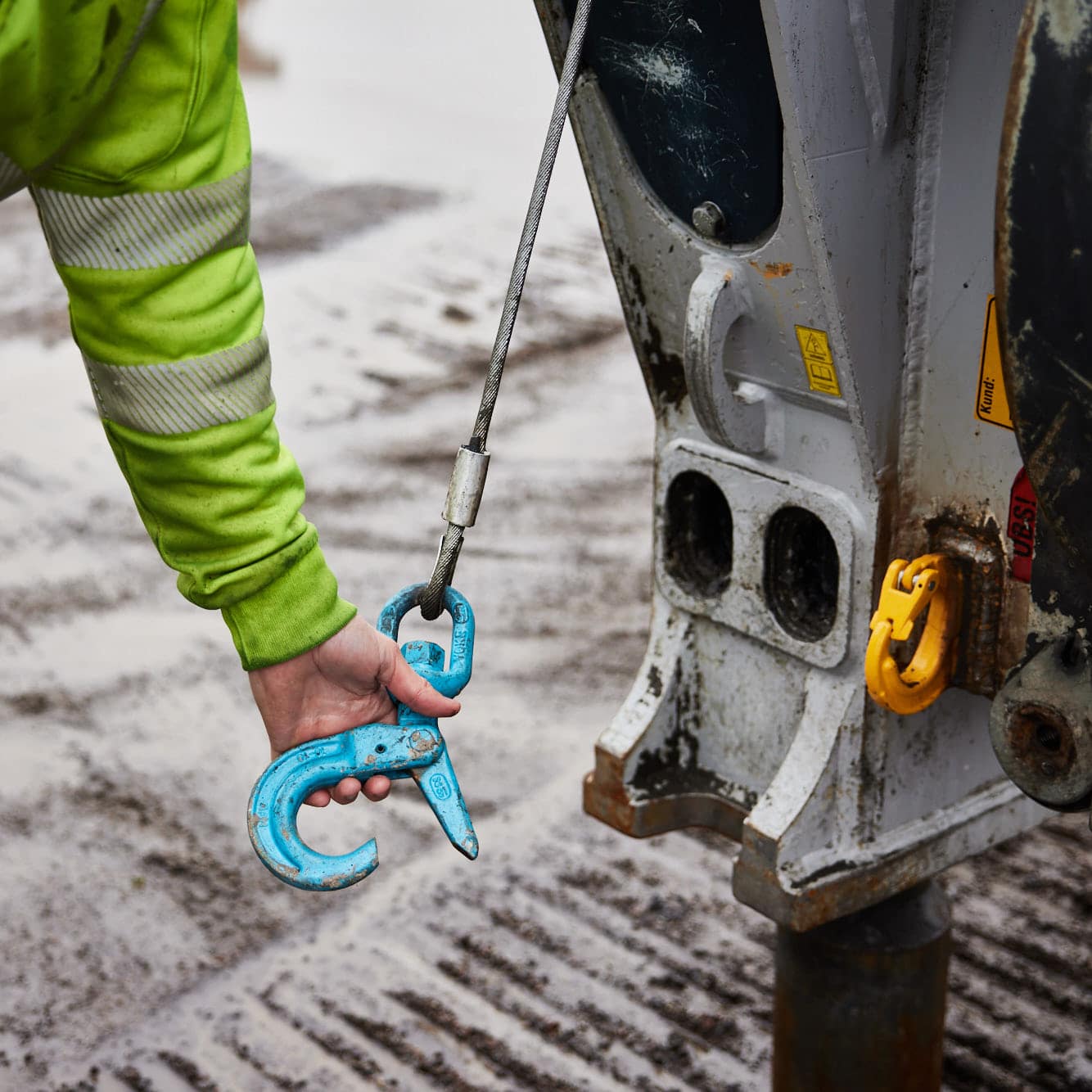 Hand som håller krok från maskin, stålpålning